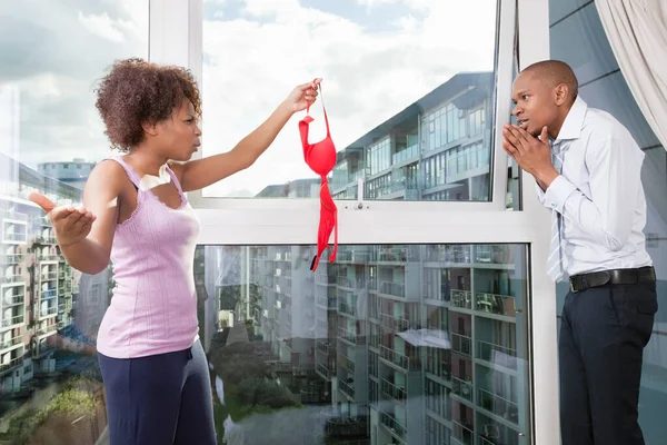 Mujer Joven Enojada Sosteniendo Sujetador Delante Hombre Culpable Casa — Foto de Stock