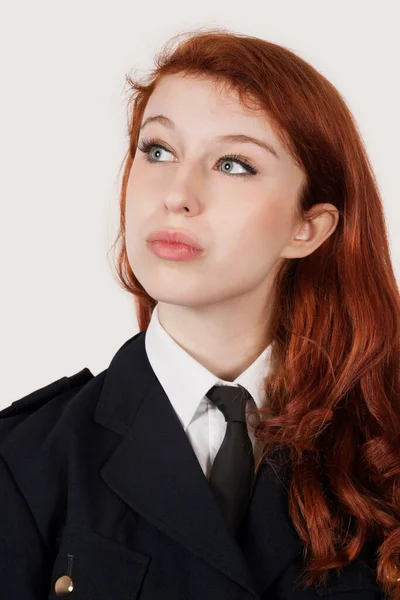 Tänksam Ung Kvinna Polis Kostym Mot Grå Bakgrund — Stockfoto