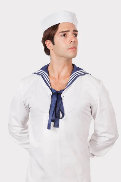 グレーの背景を背景に船員の制服を着た思慮深い若い男 — ストック写真