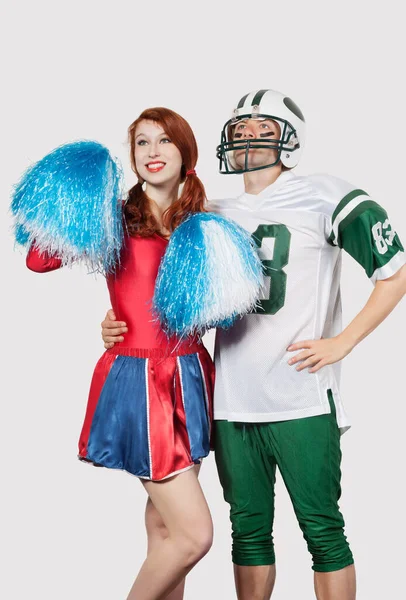 Junger Mann Fußballuniform Und Cheerleader Mit Bommelmütze Vor Grauem Hintergrund — Stockfoto