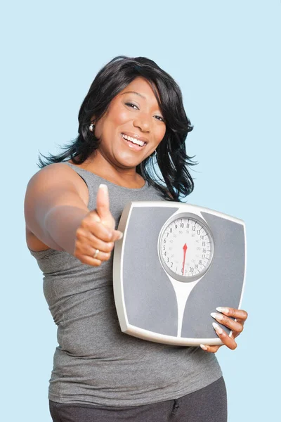 Portrait Woman Giving Thumbs While Holding Scales Blue Background — Stock Photo, Image