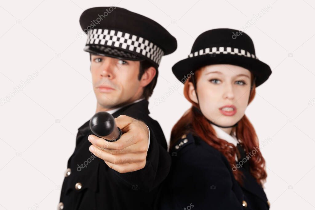 Portrait of confident police officers against gray background
