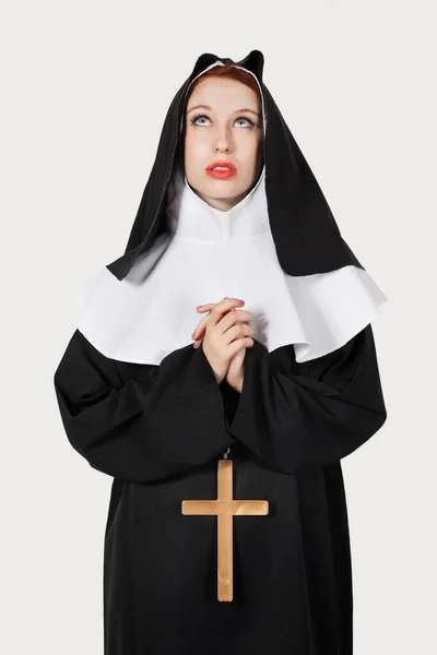 Молодая Монахиня Молится Сером Фоне — стоковое фото