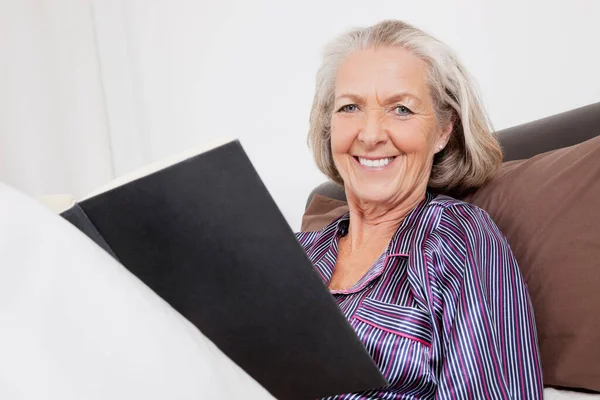 Porträtt Lycklig Äldre Kvinna Med Boken Sitter Hemma — Stockfoto