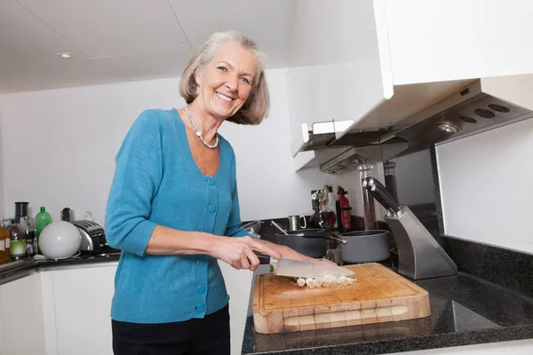 Portret Szczęśliwej Seniorki Siekającej Warzywa Blacie Kuchennym — Zdjęcie stockowe