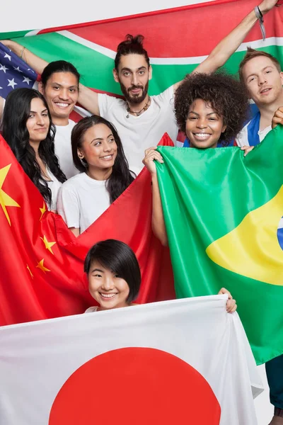 Grupo Amigos Multiétnicos Que Sostienen Diversas Banderas Nacionales Contra Fondo — Foto de Stock