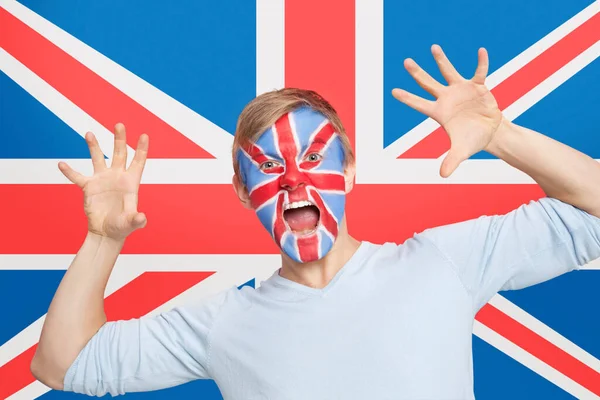 一个年轻男子的肖像 他的脸被涂成了英国国旗的尖叫声 — 图库照片