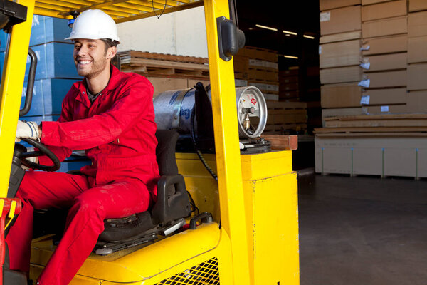 Warehouse worker using forklift truck