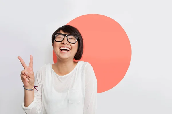 Portret Wesołej Młodej Kobiety Gestykulującej Znak Pokoju Przeciwko Japońskiej Fladze — Zdjęcie stockowe