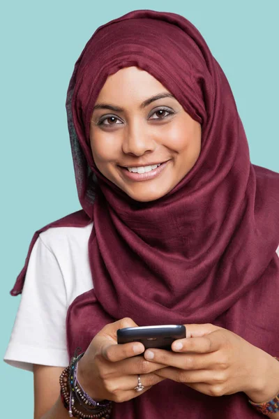 Retrato Feliz Jovem Muçulmana Usando Telefone Celular Contra Fundo Azul — Fotografia de Stock