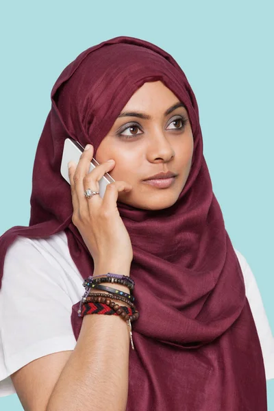 Młoda Muzułmanka Tradycyjnej Odzieży Używająca Telefonu Komórkowego Niebieskim Tle — Zdjęcie stockowe
