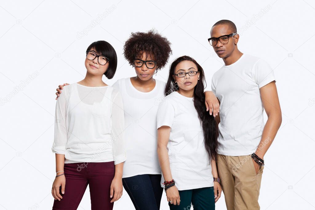 Portrait of confident multi-ethnic friends in casuals standing together over white background