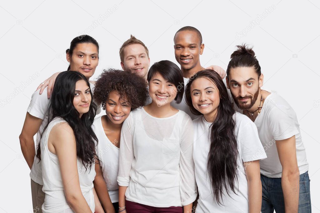 Portrait of young multi-ethnic friends smiling together against white background