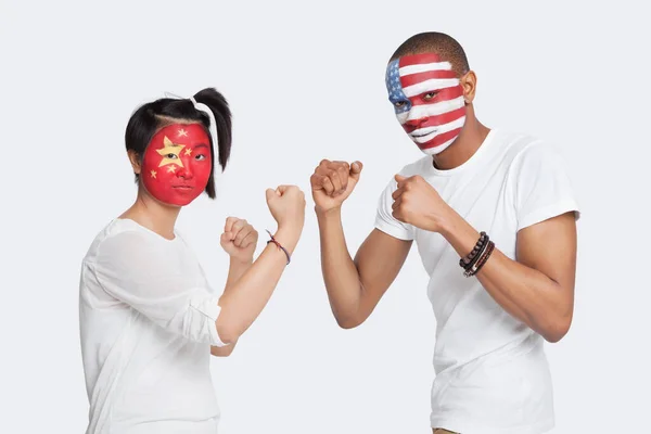 脸上挂着国旗的男女青年举起拳头与白人背景作斗争的画像 — 图库照片