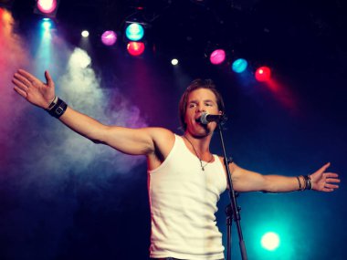 Rock konserinde şarkı söyleyen genç adam.