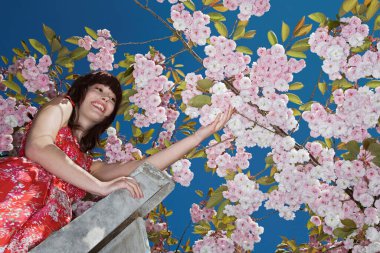 Kiraz çiçekleriyle süslenmiş güzel kızıl saçlı kadın.