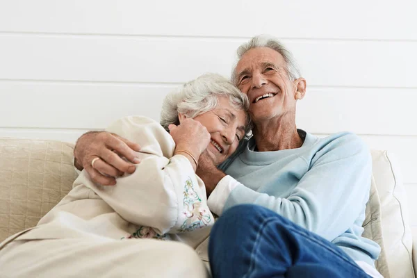 Senior Couple Hugging Sofa — Stock Photo, Image