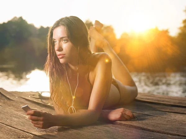 Young Woman Lying Jetty Listening Mp3 Player — Stock Photo, Image