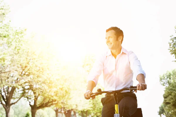 公園の晴れた夏の日の間に自転車に乗るビジネスマン — ストック写真