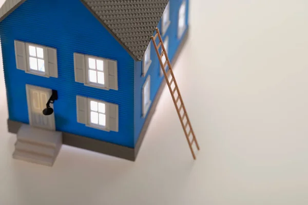 Podświetlany Mały Niebieski Model Domu Drabiną — Zdjęcie stockowe