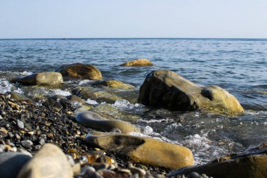 Mavi Dalgalar onlardan toz ve Karadeniz kıyısında yalan taşlar karşı çökmesini