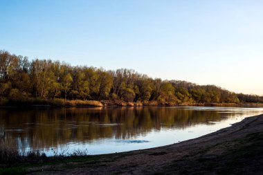 yellow, warm sunset on the banks of the Urals, and on the other side of the embankment of the city of Orenburg