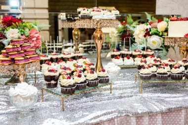 çay masası, krem, çilek ve yaban mersini ile güzel, parlak ve lezzetli cupcakes-cupcakes bir sürü