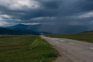 Issız bir yol ve mavi bir gökyüzü. Yaklaşan bir fırtına.
