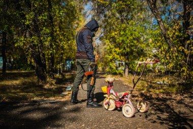 Bir Stalker 'da kostüm, gaz maskeli bir adam makineli tüfekle durur.