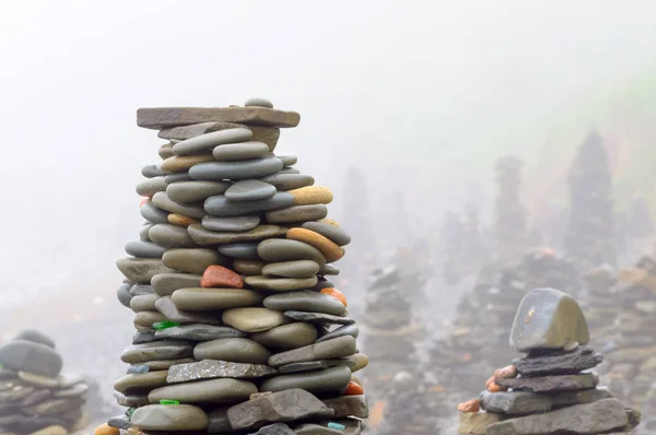 Sabah ları denizin çakıl plajındaki taş piramitler sisle kaplandı