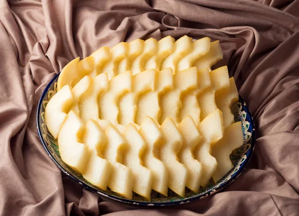 Zeppe di melone su un piatto con ornamento orientale, profondità di campo poco profonda — Foto Stock