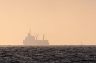 Yolda bir gemi ve akşam karanlığında bir deniz feneri.. 