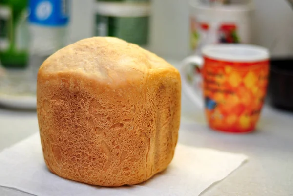 Masanın üzerinde bir somun taze ekmek, sığ bir tarla derinliği — Stok fotoğraf