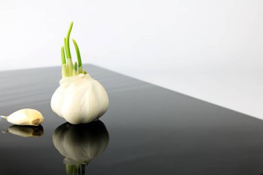 Siyah bir tabakta sarımsak geziniyor.