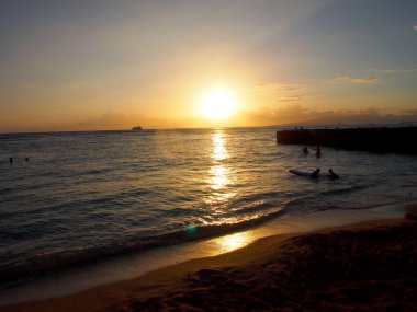 Kaimana Beach okyanusta Oahu, Hawaii su tekne ile geride bırakarak günbatımı.