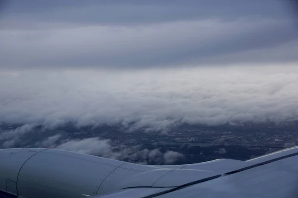 飛行機の翼は飛ぶ ワシントン州シアトル市雲で覆われています — ストック写真