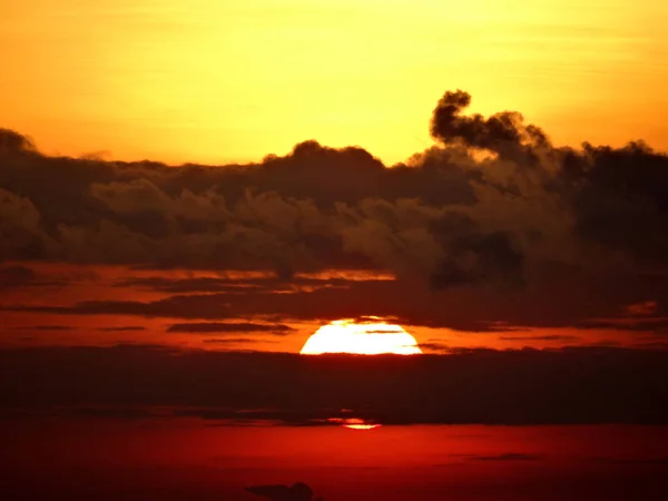 赤黄色の空と雲の切れ間から夕日 — ストック写真