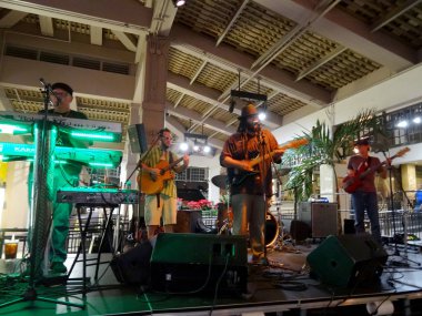Honolulu, HI - 10 Aralık 2015: Rehberlik grup şarkı ve gitar, bas gitar ve klavye Mai Tai Bar Ala Moana Alışveriş Merkezi'nde sahne alanı'nda oynayan sıkışmaları.