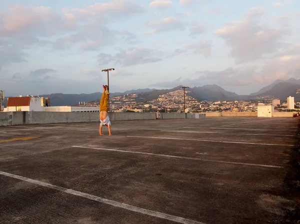 男は夕暮れ時に ハワイ オアフ島ホノルル市内の上記駐車場の最上階に逆立ち 2016 — ストック写真