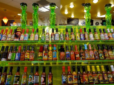 Baker, California -  July 31, 2011: Rows of Hot Sauce on Display inside Alien Fresh Jerky store. Alien Fresh Jerky is a one stop online shop for fresh jerky, beef jerky, peppered jerky, teriyaki jerky, hot jerky, spicy jerky, sweet spicy, and more! clipart