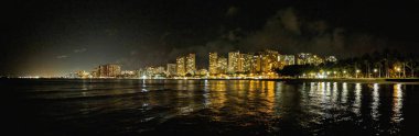 Şehir ışıkları Waikiki ve su gece yanar. Panoramik görünüm.