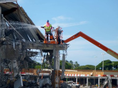 Honolulu - 6 Kasım 2013: Moloz Sears mağaza gibi yeni alışveriş kanat ile moloz Ala Moana alışveriş merkezi açmak için yıkıldı ve Oahu, Hawaii üzerinde asılı teller vinç spreyler işçi.