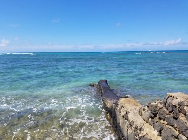 Lav kaya duvarı bu harika bir gün alıştırma Oahu, Hawaii dalgaları ile Makalei Plajı'nda okyanusa iskele.