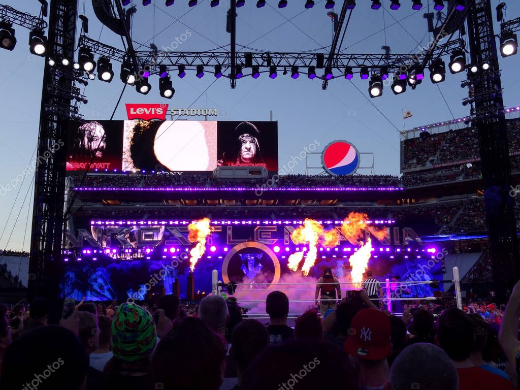 SANTA CLARA - MARCH 29: Fire shoots into the air as WWE Wrestler the Undertaker enters arena heading towards the ring with Bray Wyatt standing in that ring for match at Wrestlemania 31 at the Levi's Stadium in Santa Clara, California on March 29, 201