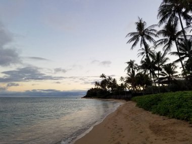 Kahala Hunakai Beach'te Oahu, Hawaii Sandy kıyı alacakaranlıkta.
