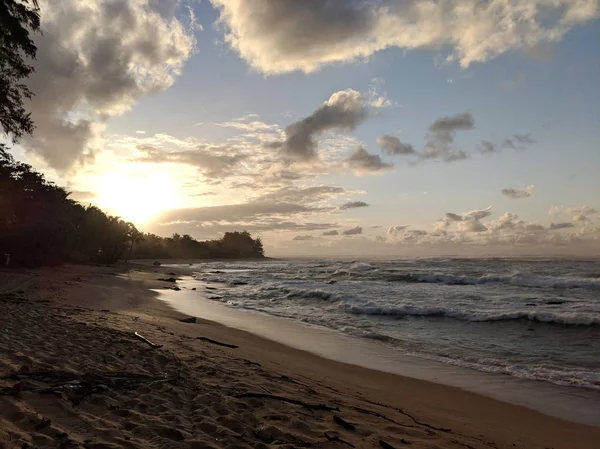 Puesta de sol sobre el océano con olas moviéndose a la orilla —  Fotos de Stock