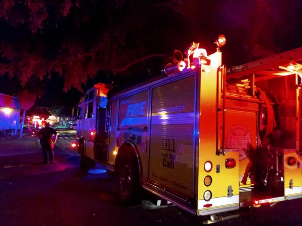 Огни пожарных машин вспыхивают в кампусе колледжа, когда они тушат пожар. — стоковое фото