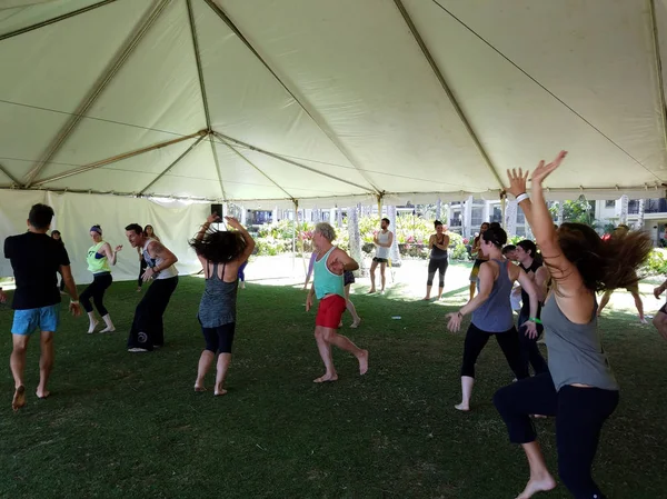 As pessoas dançam ao ar livre sob uma tenda durante a meditação extática dan — Fotografia de Stock