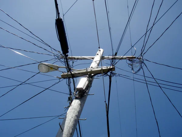 Des lignes électriques à haute tension se croisent à un poteau de service public en bois — Photo