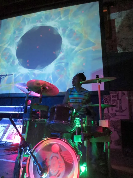 Drummer Jerome James jams on drums with trippy video show overhe — Stock Photo, Image